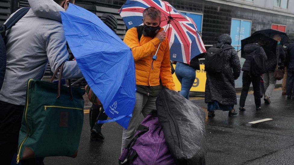 Delegates try to cope with weather conditions before entering the arena