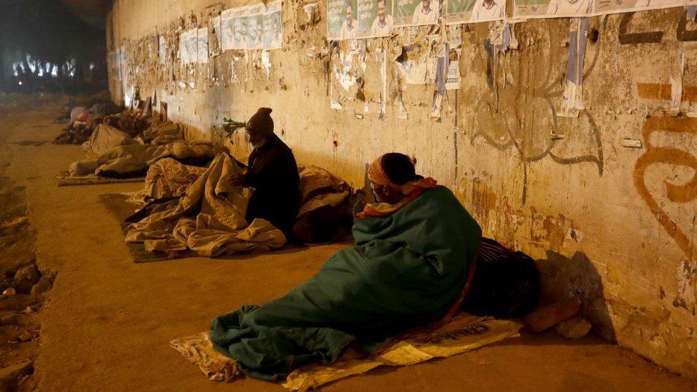 91ȱless people wrapped in layers of quilts to warm up themselves while others sleep in the open under an overpass on a coldest night on January, 04, 2023 in New Delhi, India. Weather station observatory recorded the season's lowest as temperature plunges to 4.4 degrees Celsius. (Photo by Pankaj Nangia/Anadolu Agency via Getty Images)