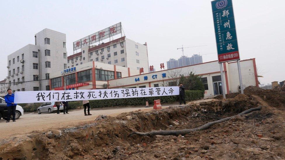 Hospital workers put up a banner saying "we are saving lives while the forced demolition is trashing lives" 07 January 2016