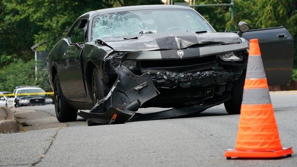 A badly damaged car after it was driven in to protesters