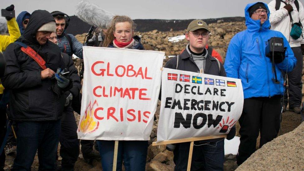 Climate-change-activitists-gathered-by-glacier-site-with-banners.