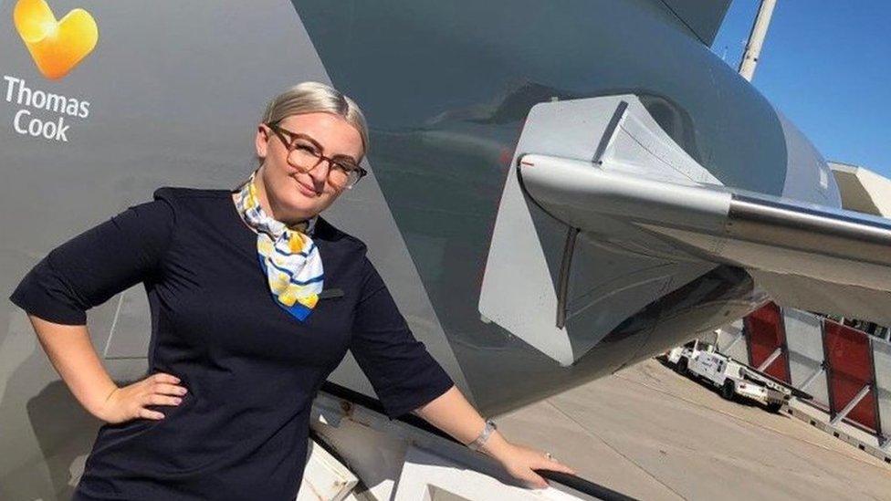 Ella Waine standing next to a Thomas Cook plane in her cabin crew uniform