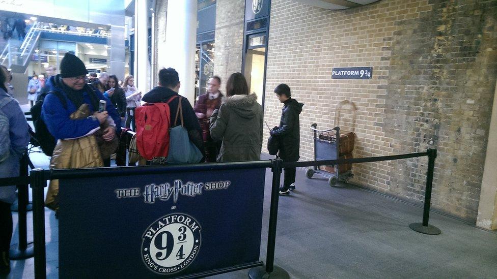 People having their picture taken at Platform 9 and 3/4s