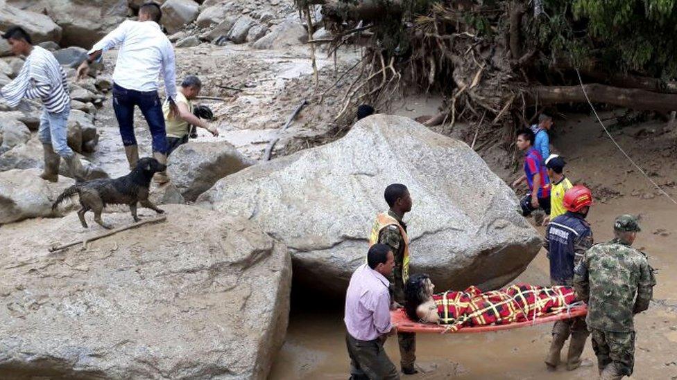 A woman being carried by rescue workers