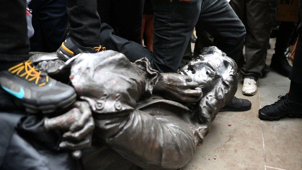 Black Lives Matter protesters stand on the statue of Edward Colston in Bristol