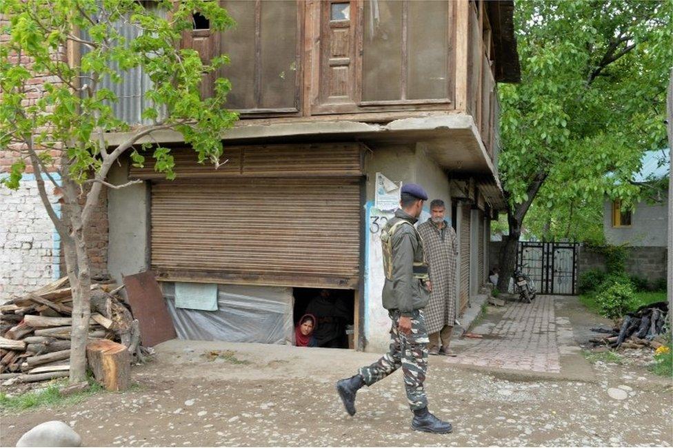 An Indian army soldier speaks with residents during an operation against suspected rebels in Turkwangam Lassipora in Shopian south of Srinagar on 4 May 2017