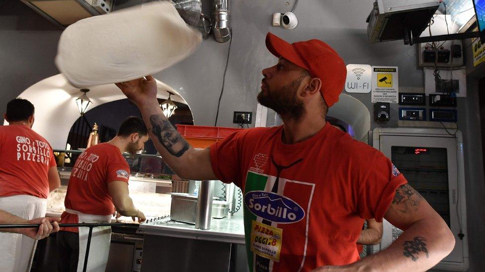 Man spins pizza dough