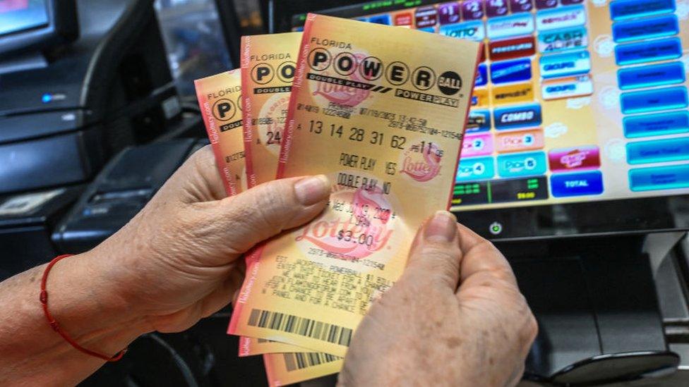 A woman holds Powerball lottery tickets inside a store in Homestead, Florida on July 19, 2023