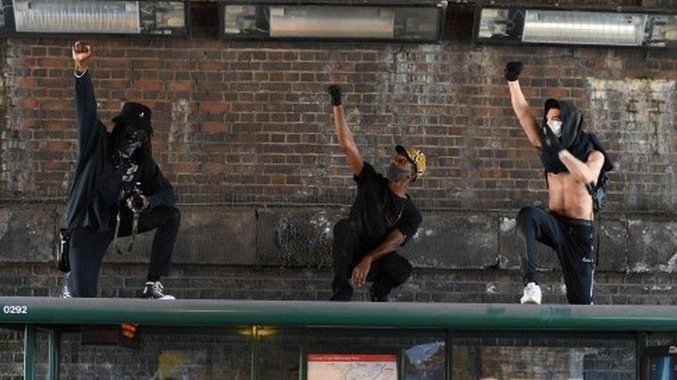 Three men demonstrate on top of a bus stop