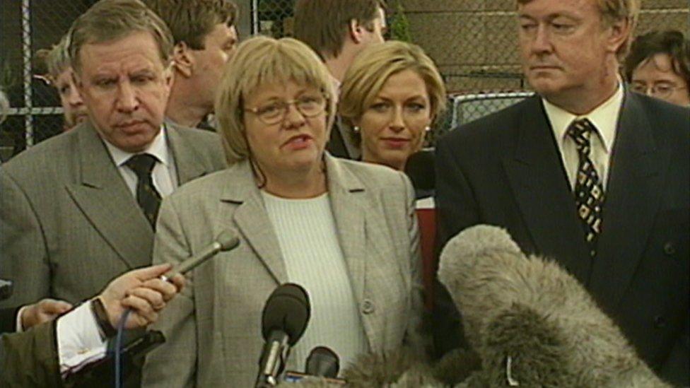 Mo Mowlam speaking to the media flanked by Paul Murphy on left