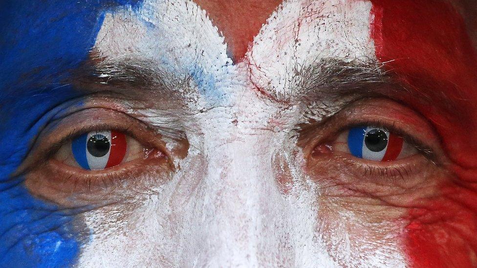 Man wearing face paint like the French flag