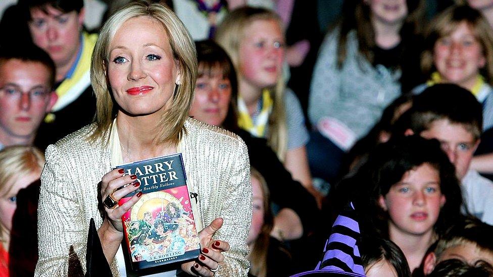 JK-Rowling-holds-a-copy-of-harry-potter-surrounded-children