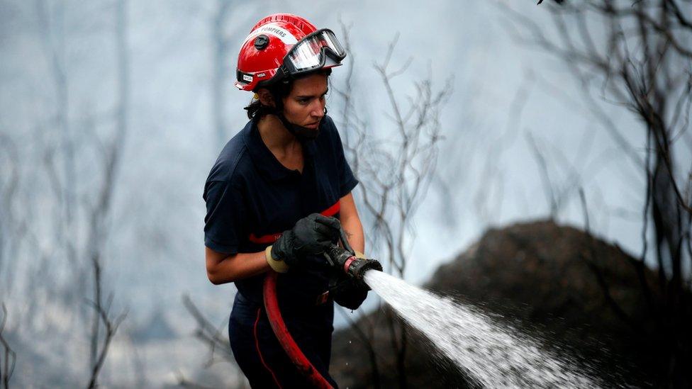 A firefighter tackles a forest fire in Carros near Nice, southern France