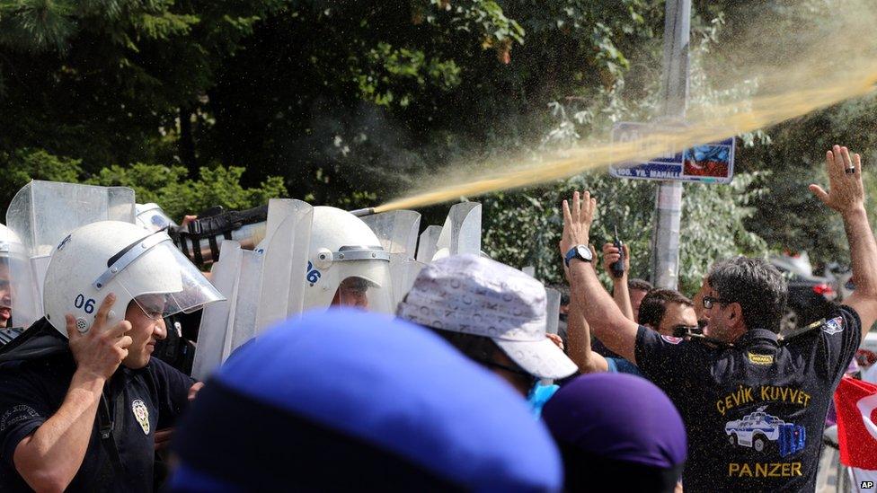 Riot police use pepper spray to push back a group of Uighur protesters who try to break through a barricade outside the Chinese Embassy in Ankara, Turkey, Thursday, June 9. 2015