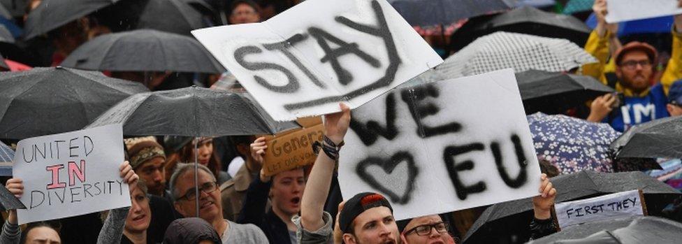 Signs reading "stay" and "we love EU" at a rally on June 28