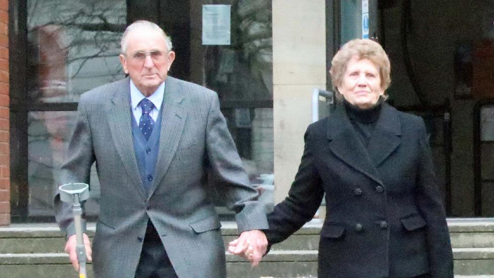 Kenneth Hugill, leaves court with his wife