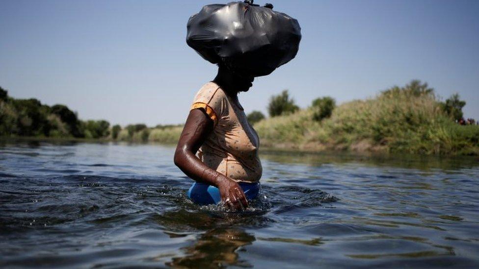 A migrant woman asylum seeker walks through the Rio Grande river to cross the border between Ciudad Acuna, Mexico and Del Rio, Texas