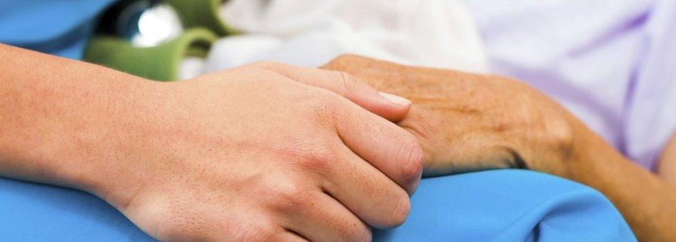 Nurse holding patients hand