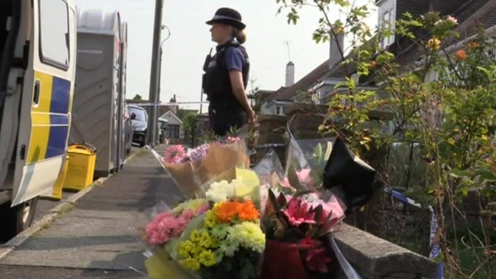 Police and flowers outside Shana Grice's home