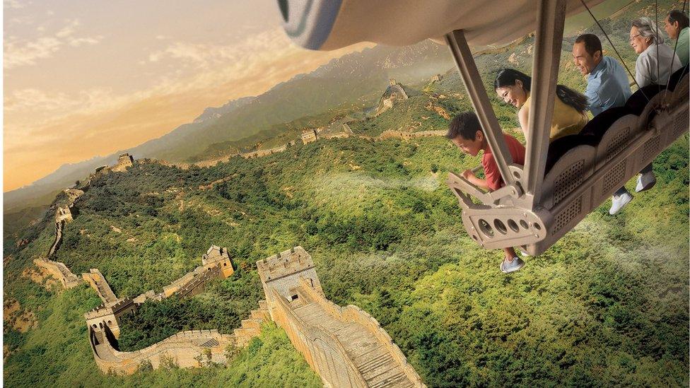 Computer generated image of a family on a ride, soaring above a panorama of the Great Wall of China.