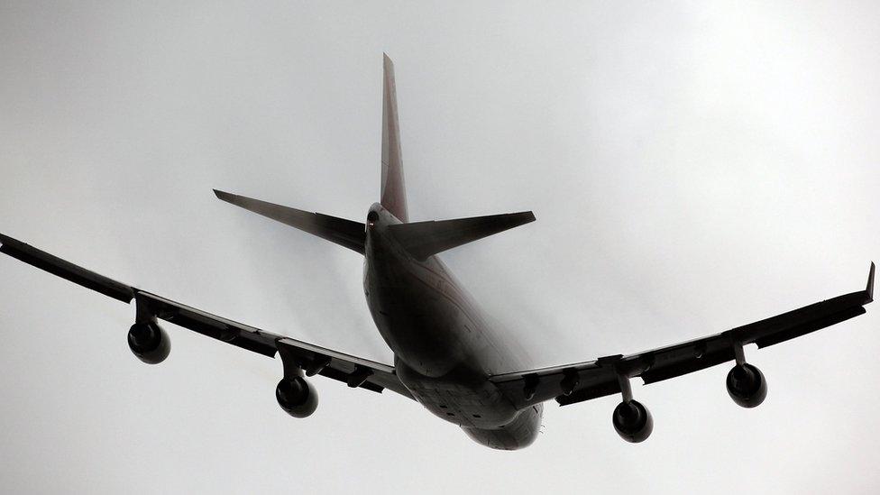 Vapour forms over the fuselage of a passenger jet as it takes off from Heathrow airport on January 15, 2009