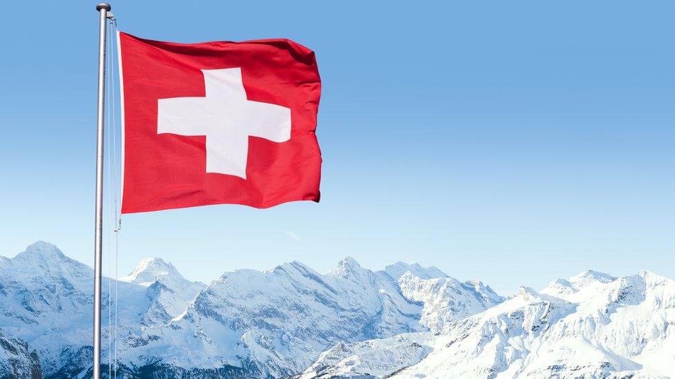 Swiss flag with Alpine scenery