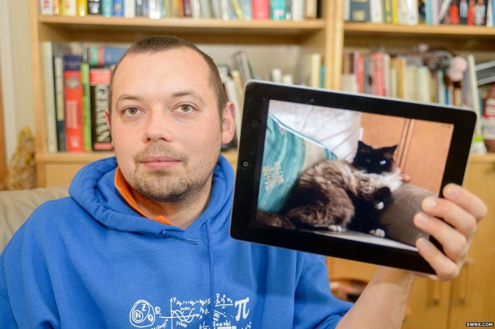 Richard Beeson pictured with a photo of his cat Ukiyo, four, who was found dead on a neighbour's door step