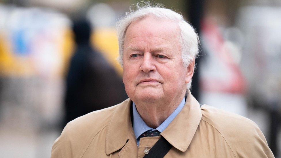 Bob Stewart, wearing a beige mac and a blue shirt, arriving at Westminster Magistrates' Court