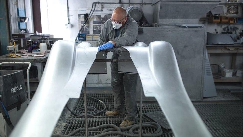 An employee of The Morgan Motor Company work in the paint shop of the car firm's factory in Malvern, southwest of Birmingham, central England on August 13, 2019. - The Morgan Motor Company was established in 1909 by H.F.S Morgan and have been