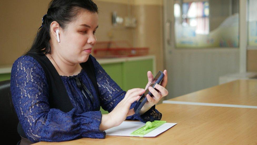 A blind woman using a smart phone with voice accessibility technology