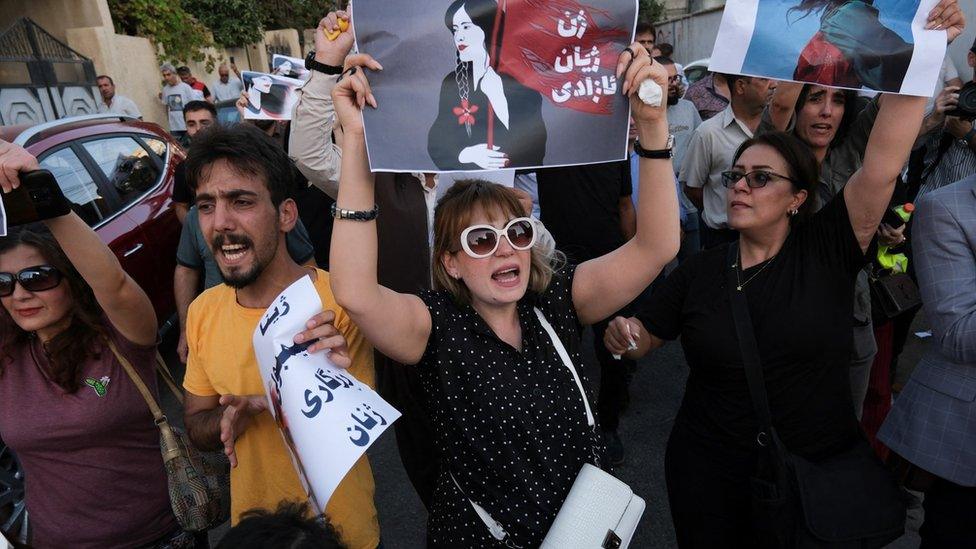 A woman holds a placard during a protest following the death of Mahsa Amini and an Iranian attack on Iraq's Kurdistan Region, in Sulaimaniya, Iraq (28 September 2022)