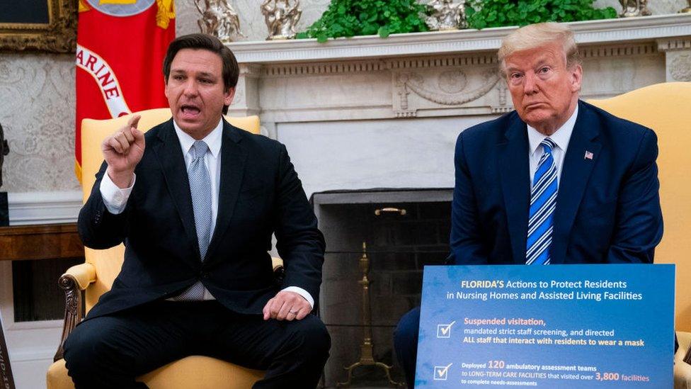 Ron DeSantis and Donald Trump sitting down at the White House in April 2020