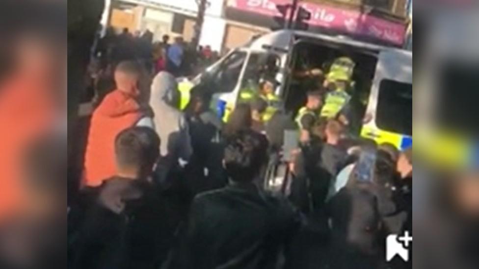 Police van and people gathered in the centre of Bradford