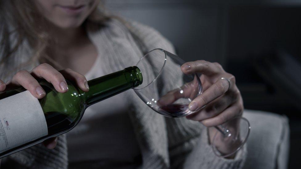 A woman pouring a glass of wine