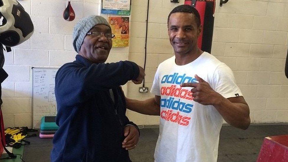 Stanford Robinson left points at at his so Steve. The pair are photographed in a boxing gym.