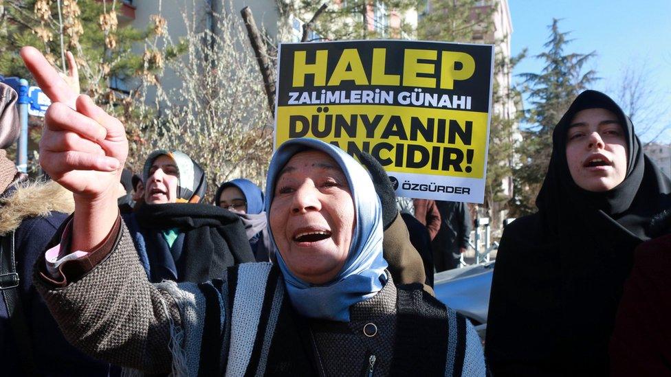 Protesters in Turkey hold a placard reading "Aleppo is the world's shame" (15 Dec)