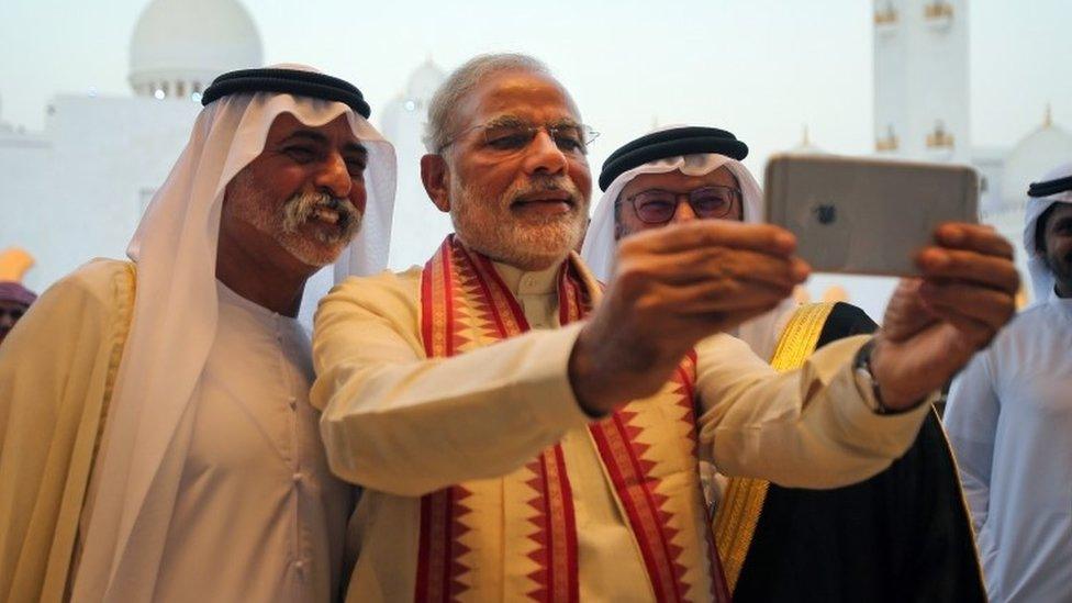 Indian Prime Minister Narendra Modi, middle, takes a selfie next to Sheikh Hamdan bin Mubarak Al Nahyan, UAE Minister of Higher Education and Scientific Research, left, as they tour the Sheikh Zayed Grand Mosque during the first day of his two-day visit to the UAE, in Abu Dhabi, United Arab Emirates, Sunday, Aug. 16, 2015.