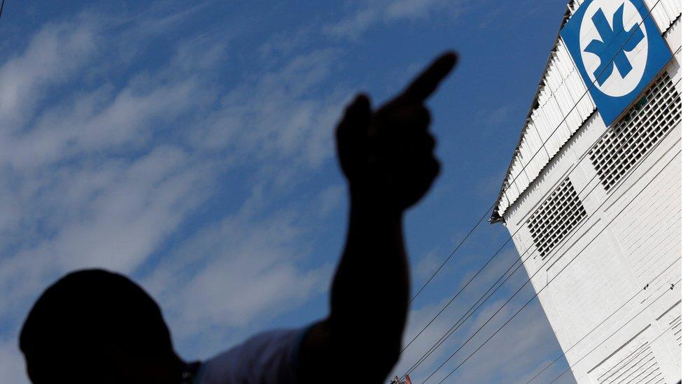 silhouette of man pointing at Kimberly Clark logo, 10 July 2012