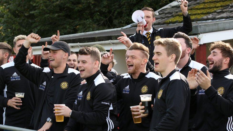 Fellow club members cheer on from the club's stand