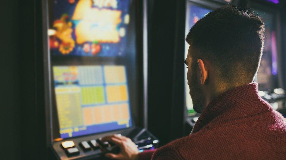 Man gambling on fruit machine