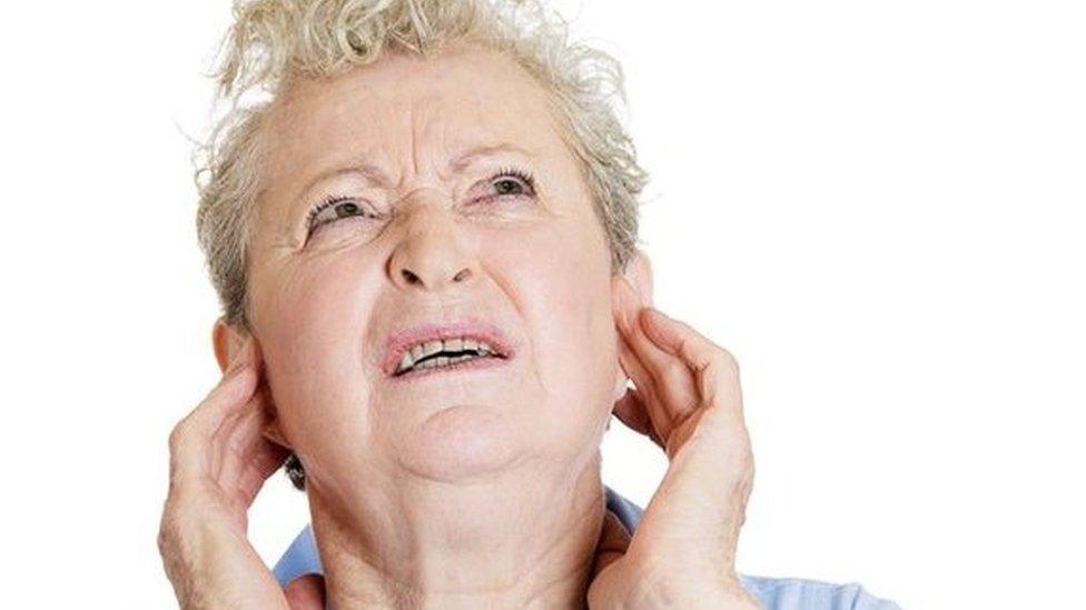 Woman puts fingers in her ears