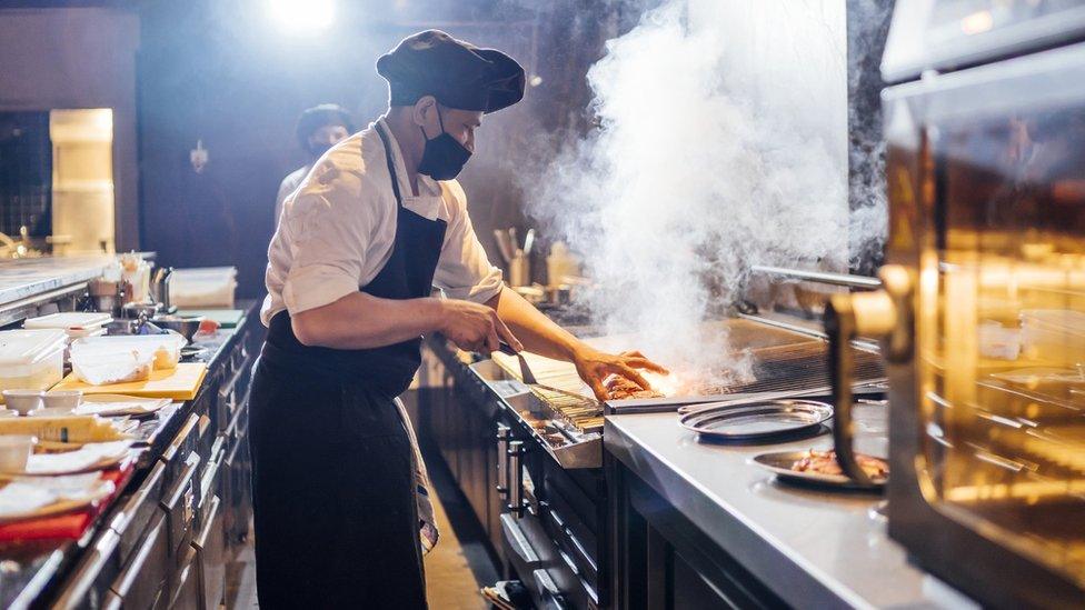 Chef cooking wearing face mask.