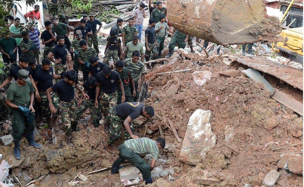 Sri Lankan military rescue workers recover the body of a man in the rescue operations at the site of a collapsed garbage dump in Colombo on April 15, 2017.