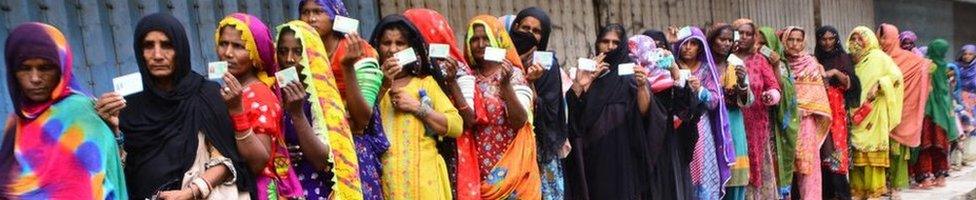 Flood victims queue up outside a bank to receive financial assistance in southern Sindh province