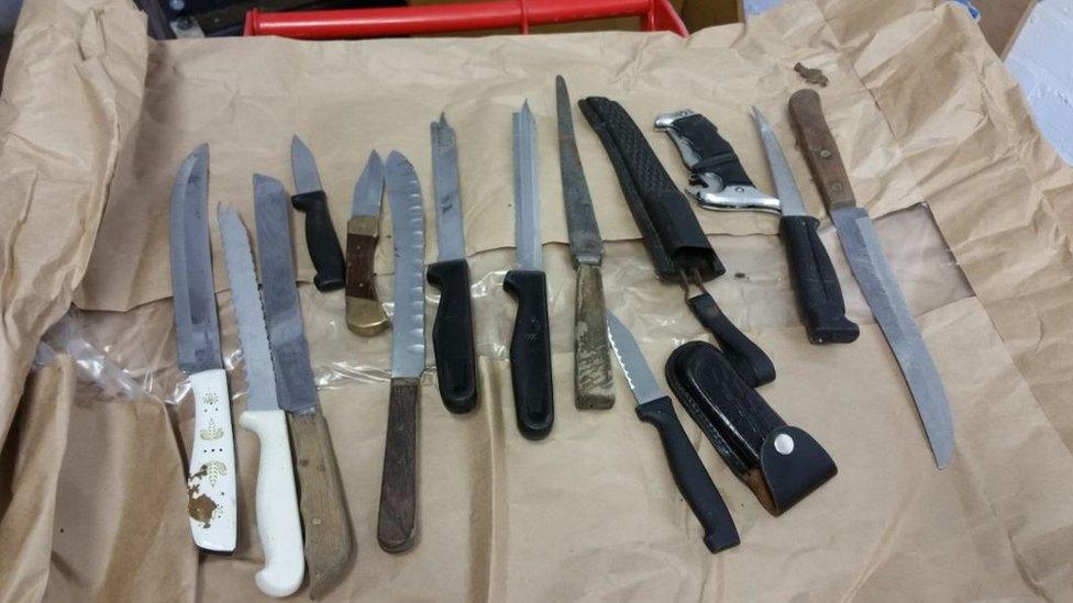 Several knives and weapons laid out on a table