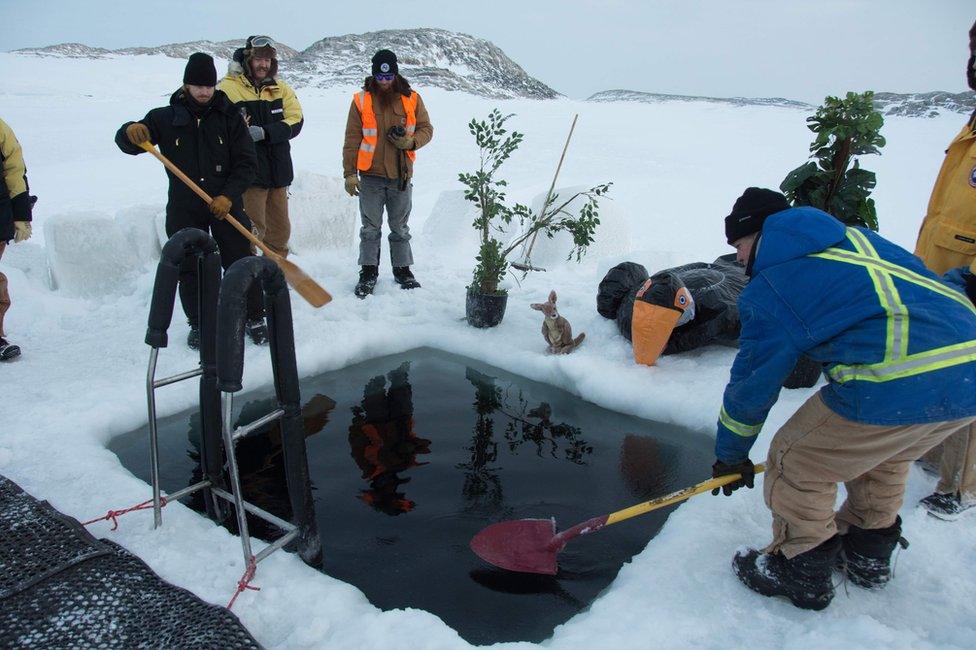 Members of the Australian Antarctic Division (AAD) at the Casey research station cut through thick ice