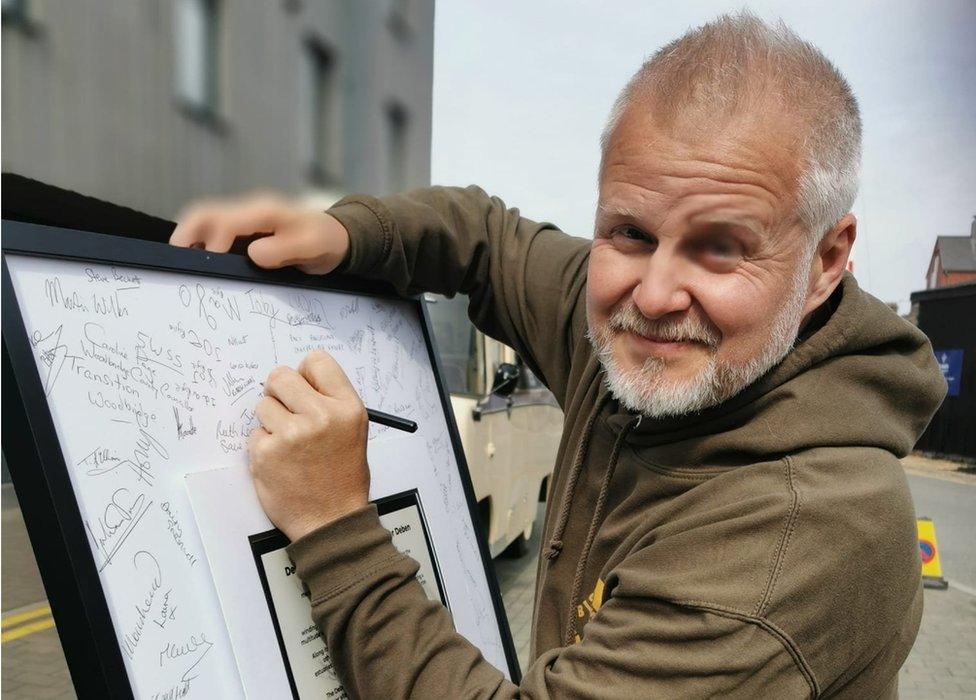 A member of the public signing his name in favour of the reapplication for bathing water status for Woodbridge