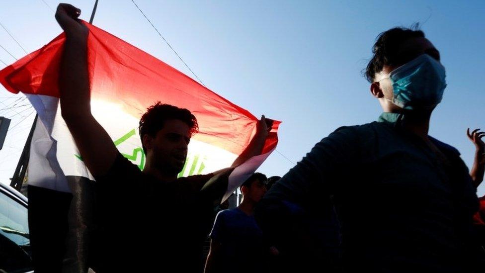 An Iraqi protester waves a flag in Basra