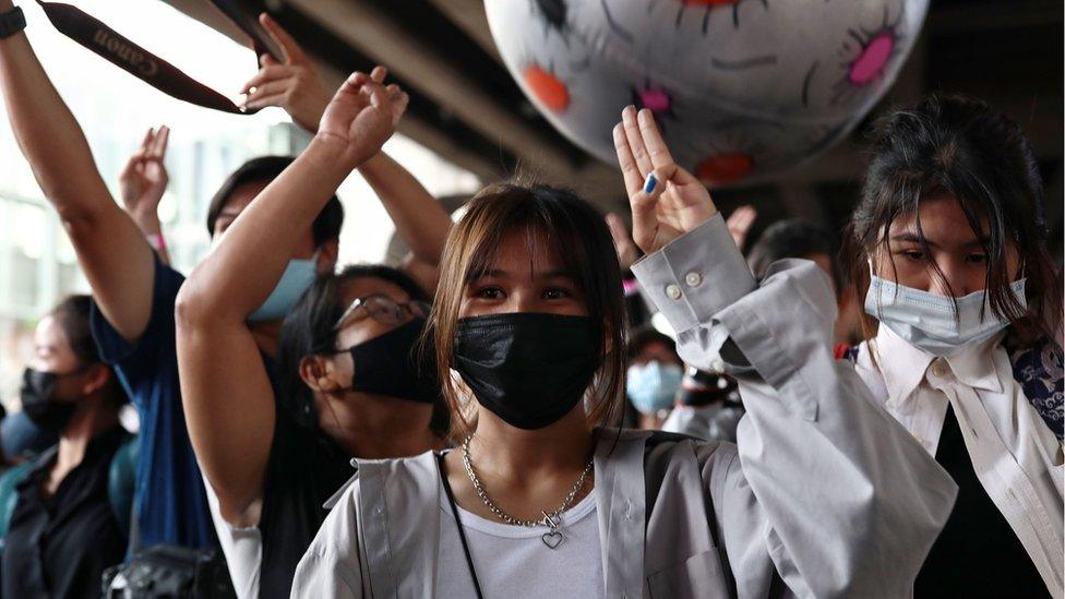 Protesters hold up the three-finger salute during a rally in Bangkok, 21 November 2020