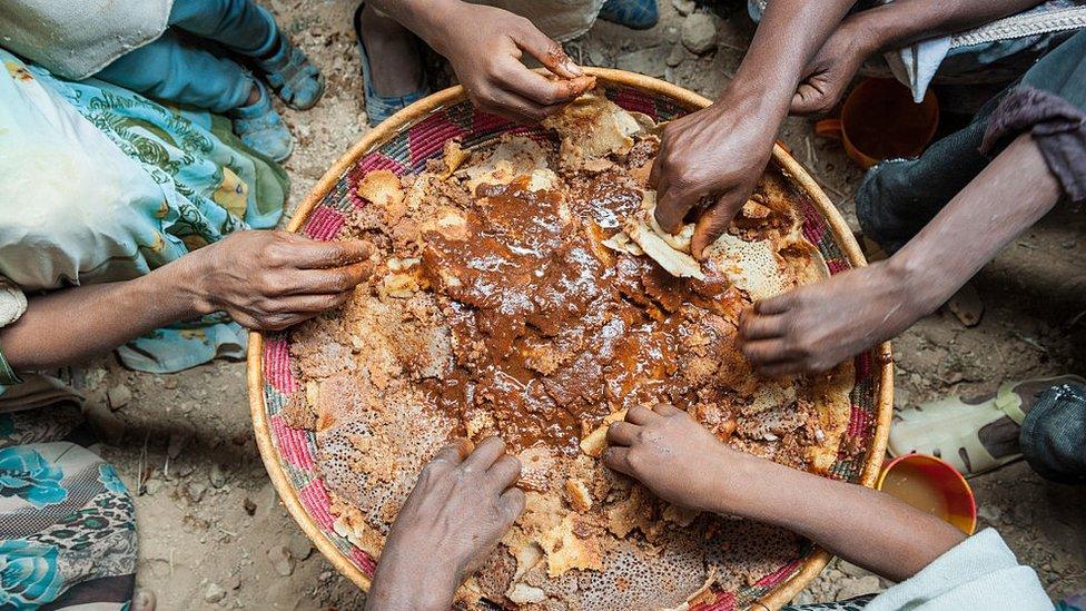 Hands of people sharing a traditional dish (archive)